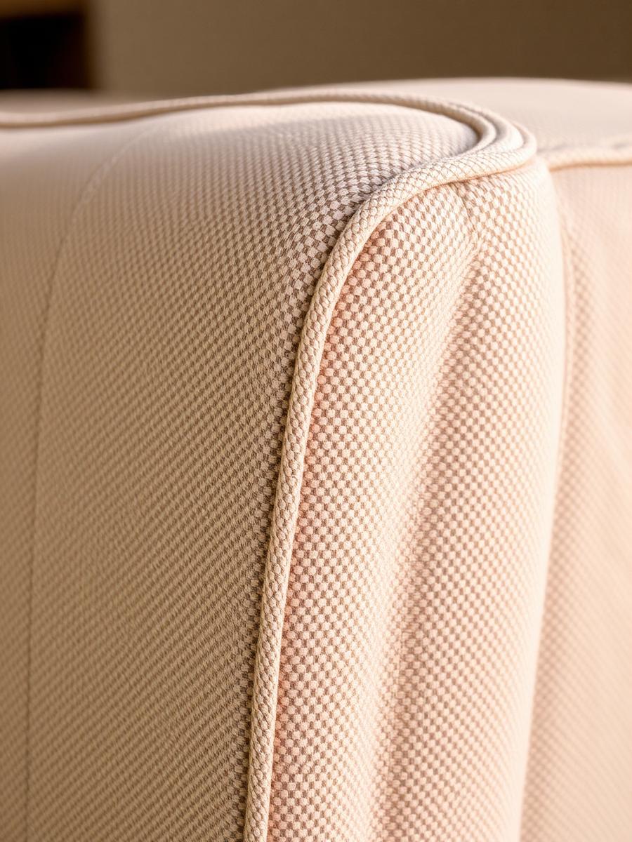 Close-up of premium beige upholstery fabric and stitched piping